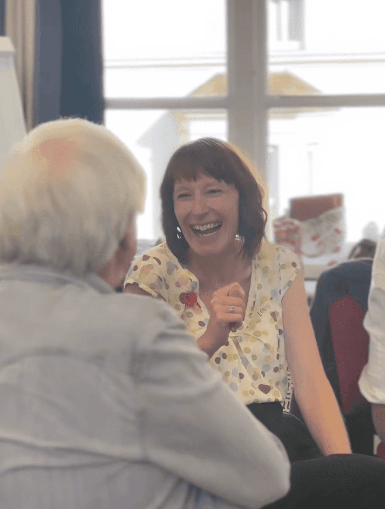 A photo of a woman in Sandown Library, laughing. 