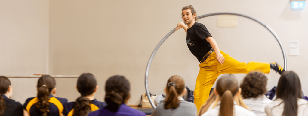 Thorne Bailey, a full-time circus performer on his Cyr Wheel infront of students.