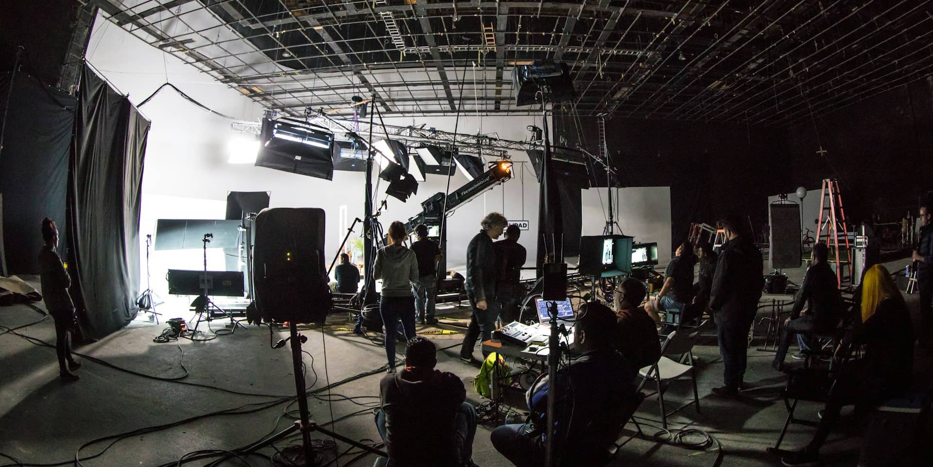 Inside a film studio, showing equipment and people working