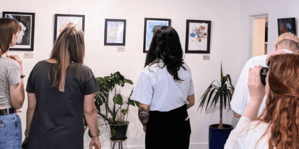 Young people looking at art displayed on a gallery wall