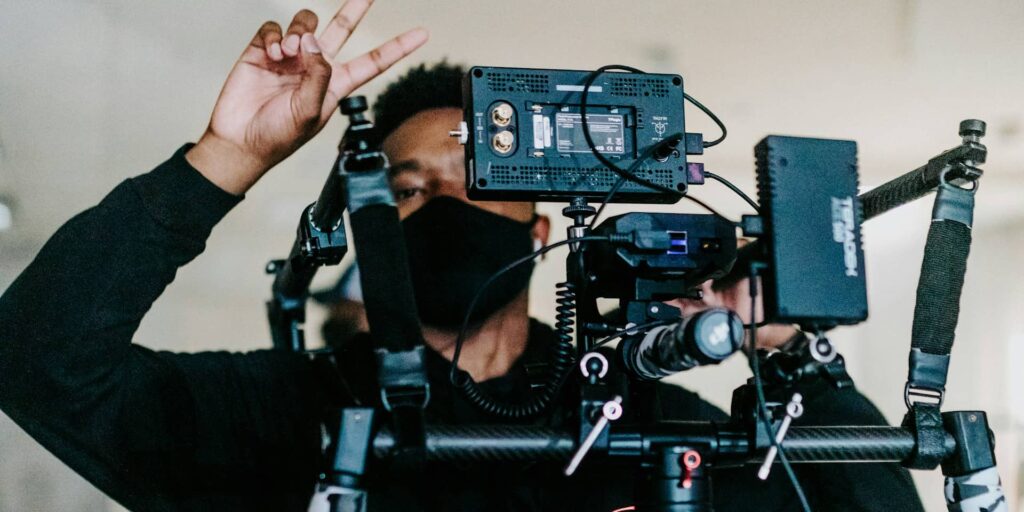 Man holding lots of film making equipment