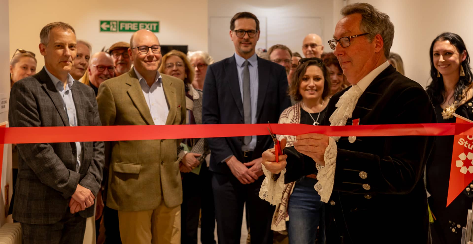 High sheriff cutting the ribbon to the exhibition, with supporters in the background