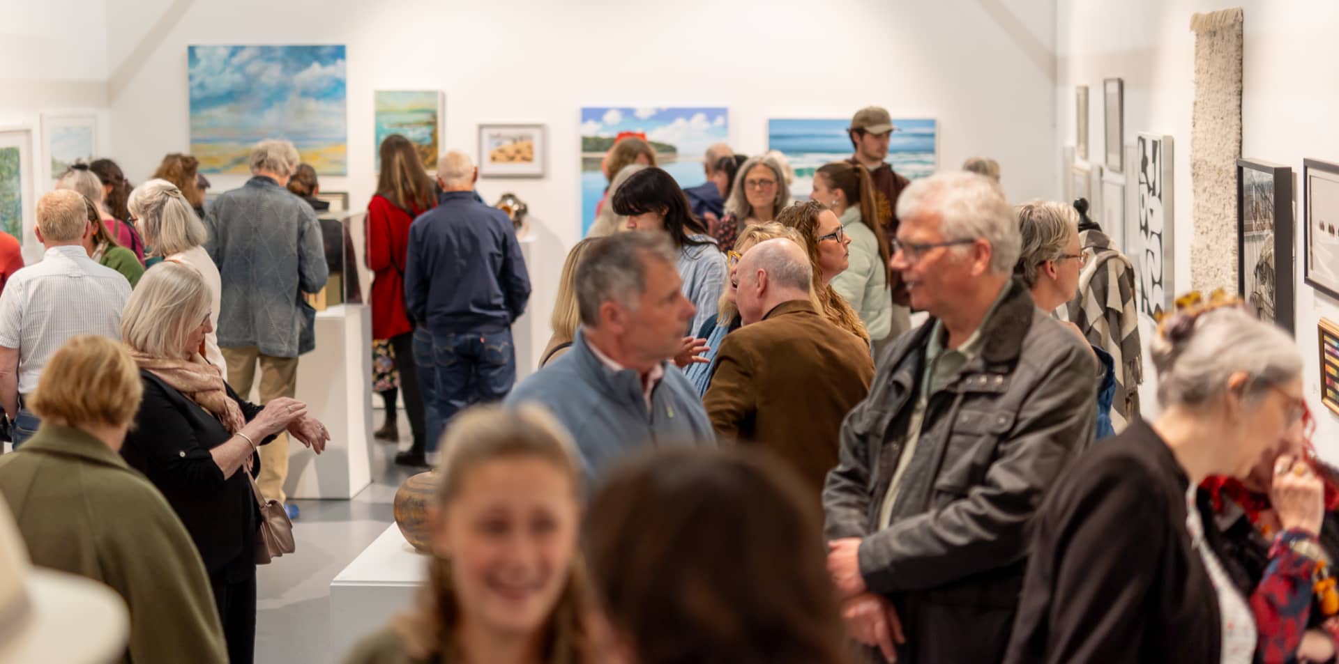 Visitors to the exhibition viewing the art in the West Gallery
