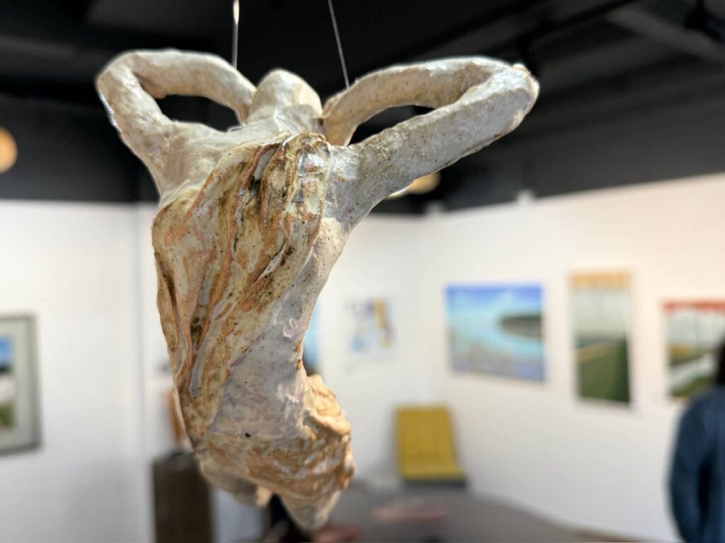 Ceramic acrobats sculpture by Gillian Clarke hanging from the ceiling at The Mead Gallery