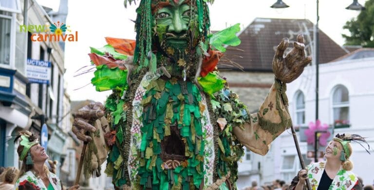 Photo of a giant Green Man carnival puppet being led down the street with New Carnival's logo overlaid on top