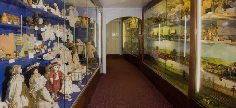 Display cabinets inside the Lilliput Museum showing lots of vintage dolls
