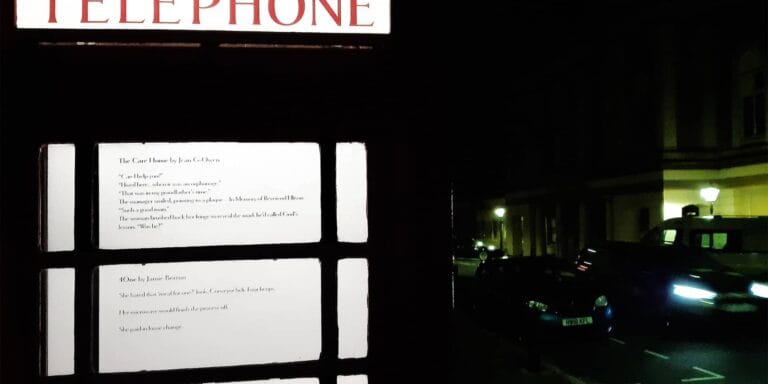 Night time shot of the gallery with windows backlight and street scene beyond
