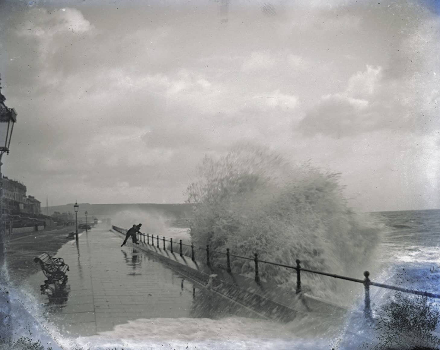 Damaged negative capturing a dramatic high tide in the Bay with someone walking close to the railings and being covered in waves