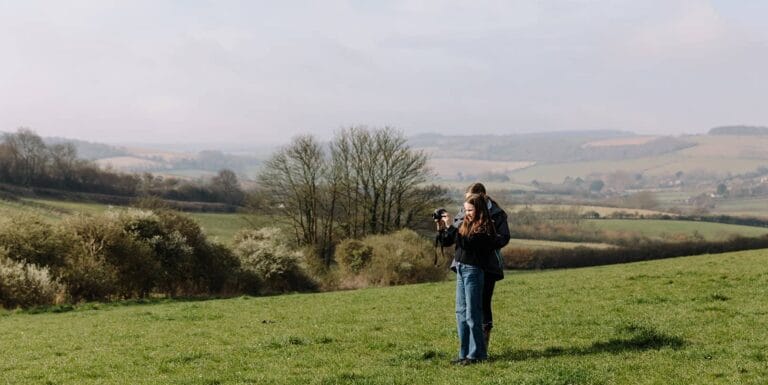 Young people in a field taking photographs