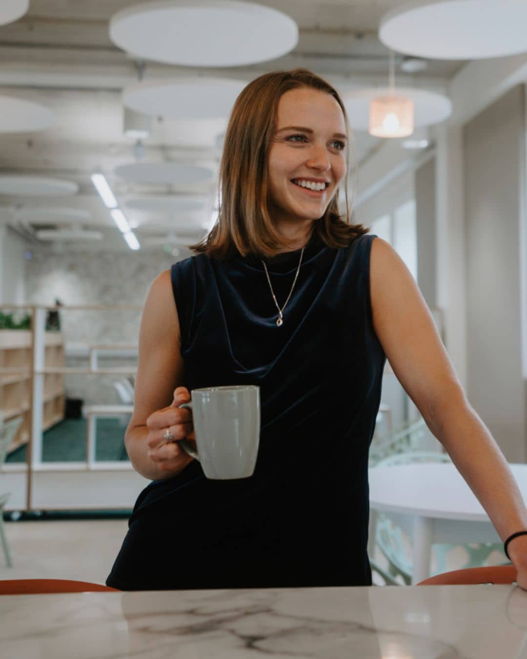 Ella Clapham from Isle of Wight Council's Regeneration team joins Creative Island's Board of Trustees. She's smiling with a cup of tea, and wearing a navy blue dress. 