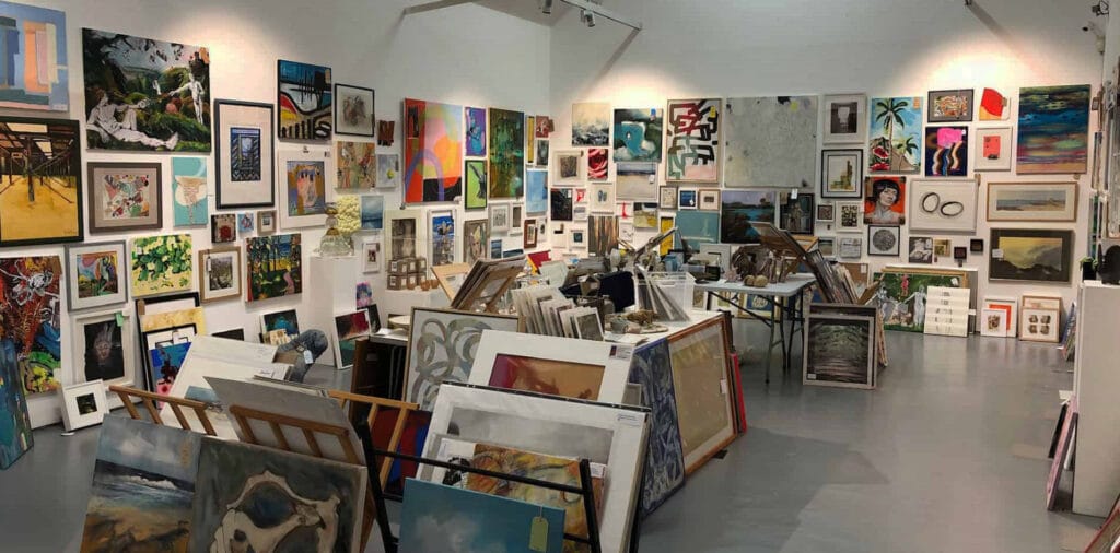 Paintings hung in salon style at Under the bed sale at Quay Arts in 2025