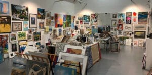 Paintings hung in salon style at Under the bed sale at Quay Arts in 2025