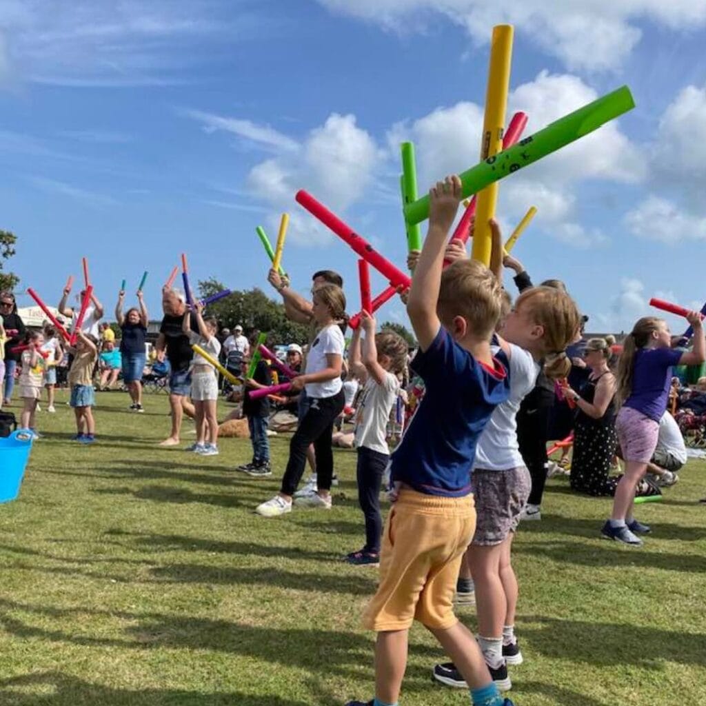 Young kids waving colourful sound tubes!