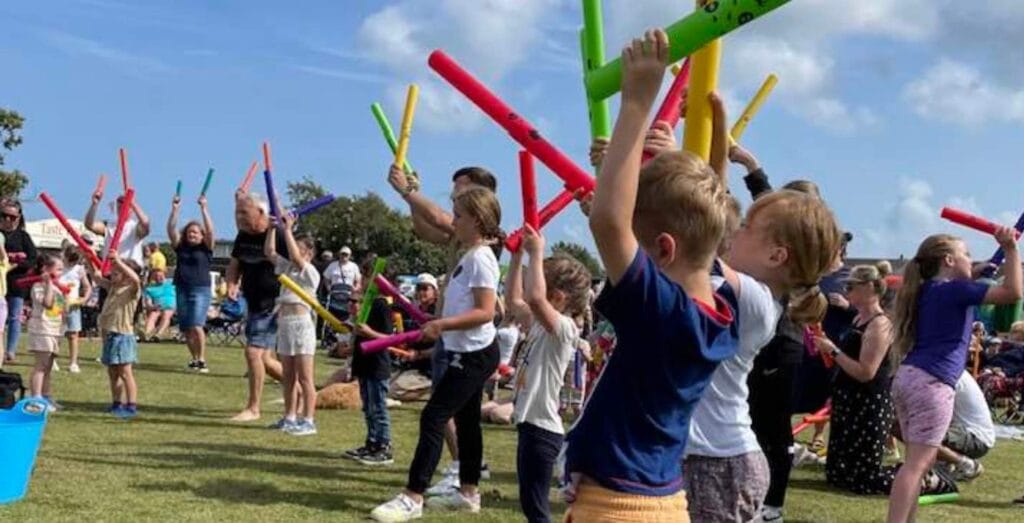Young kids waving colourful sound tubes!
