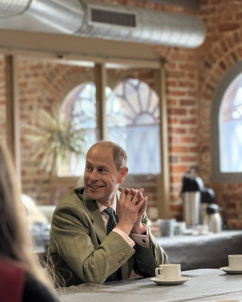 HRH The Duke of Edinburgh smiling. He is well lit in Quay Arts Seminar Room.